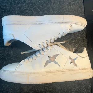 Arigato skor - Hej jag säljer dessa vita skor från Axel arigato i bra skick förutom att de är nötta inuti skon vid hälen, lite smutsiga sulor och creasade. Skulle säga att den är Sanna till storlek n, passar 38.5-39. Hör av er om ni är intresserade