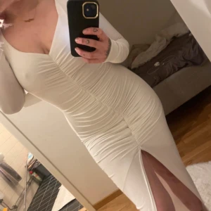 Rebecca Stella klänning - Jättefin vit klänning från Rebecca Stella med resår både baktill och framtill. Klänningen är kortare framtill och blir längre på sidorna och baktill. Pris 699:-