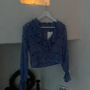 volangblus från zara  - super fin blus med blå detaljer och volanger. helt oanvänd med prislapp på! slutsåld på hemsidan. passar super bra nu till sommaren. köparen står för frakten🙌🏼😇❤️