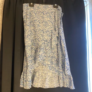 Sommarkjol - En fin luftig sommarkjol med en fin knytning och dragkedja på sidan. Den går ner till knäna så den är inte för kort.