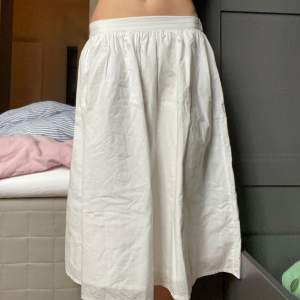 En vit kjol i bra skick som går över knäna. 100% bomull och två tunna lager. Original pris är 279kr. Använd 2 gånger. 