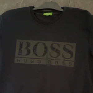 Hugo boss sweatshirt - Mörkblå/svart sweatshirt från Hugo boss, vet inte var den är köpt för jag har ärvt den, skick: 7/10, storlek:M