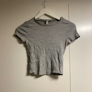 Grå topp - Grå topp från hm, fått av vän. Sömmen har gått längst ner, se bild 2 och 3. Kort modell