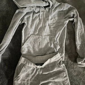 Juicy Couture Grå track suit - Denna dressen är i väldigt fint skick och inte använd ofta. Den är i storlek S men passar XS fint. Tight i storleken. Den har fickor där bak med knappar.  Original pris är 2500 kr 