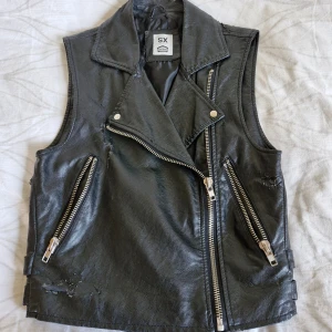 Fakeläderväst Crocker - Väst från Crocker som varit emd om mycket 😅 Nedsatt pris då ytan är repig och "lädret" har börjat flagna. Kanske finns det någon där ute som kan uppskatta den även i detta skick?  Pris är diskuterbart då den bara ligger och dammar hos mig!