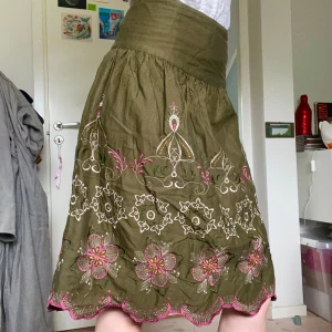 Khakigrön kjol med broderier - Fin sommarkjol från Promod med broderi i cerise, puderrosa, gult och mörkgrönt. Storlek 38 men passar mig som är en 36:a, 100% bomull med innerlig av polyester. Perfekt skick!