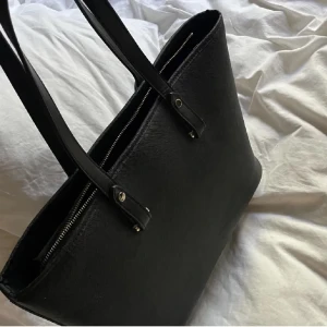 Hm handväska !! - Lånade bilder. Använd mycket men bra skick!! Perfekt inför skolan och gott med utrymme och tillräckligt mycket plats för en dator t.ex + mer ❤️❤️ SLUTSÅLD PÅ HEMSIDAN!! djup: 15cm, höjd: 30cm, bredd: 36cm