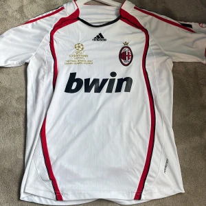 Ac Milan tröja från 2007 med kaka på ryggen  - Milan tröja med kaka på ryggen ifrån 2007 den är i bra skick men det finns en liten fläck på bröstet som ni ser på bild 5. Är öppen för byten