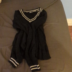 Svart sweatshirt med vita streckor - Fin sweatshirt med vita sträckor vid armarna och halsen! Fint och i bra skick. Har bara använt några fåtal gånger, sen har inte kommit till användning!