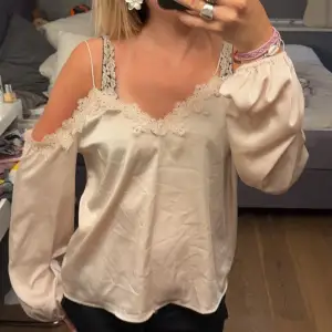 En elegant beige offshoulder topp från Bik Bok med spetsdetaljer runt halsringningen och ärmsluten i storlek M. Toppen har långa ärmar och tunna axelband. Jätte skönt material. säljer för rimligt pris💕