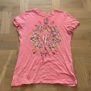 Rosa/aprikos juicy couture tshirt - Rosa/aprikosfärgad juicy couture tshirt. Ett par rhinestones har trillat av, skriv för bilder på det, annars i bra skick. Skriv om du har frågor eller för fler bilder, använd gärna köp nu💕
