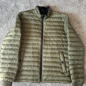 Dunjacka - Tommy Hilfiger - Oanvänd dunjacka från Tommy Hilfiger. Storlek L med nypris 1600kr. 