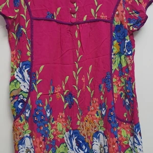 Blommig klänning - En färgglad klänning med blommönster i blått, grönt, vitt och orange på en rosa bakgrund. Klänningen har korta ärmar och knappar framtill.