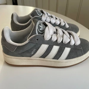 Adidas Campus 00 - Säljer ett par populära adidas campus 00 i fint skick. Storlek 38 i färgen mörkgrå. Säljer för att de är för små. De är slutsålda nästan överallt. Skriv om du har frågor💕