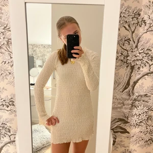 Klänning  - Sommarklänning långärmad i vit/beige med snygg knytning i ryggen! Använd ett fålar gånger så är i snyggt skick. Från Pull&Bear i storlek S.