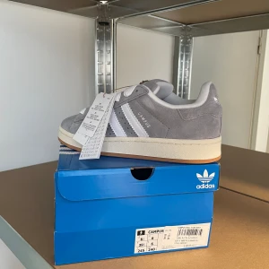 Adidas Campus 00 - Säljer ett par helt nya gråa  adidas campus 00 i storlek 39 och 1/3. Pris 1600kr, kvitto och extra snören finns.