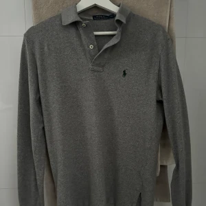 polo ralph lauren piké - säljer nu denna snygga gråa stickade långärmade pikén från ralph lauren. Den är xs men är stor i storleken så passar dig bäst som är ca 180lång! retail pris ligger på 1499kr. skicket är 10/10 och är använd någon enstaka gång. skriv vid frågor&bilder😊