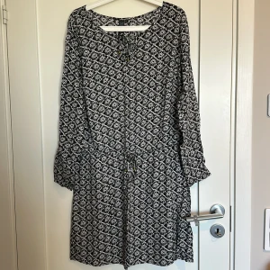 Klänning  - En klänning i fint skick med resor i midjan med lite detaljer.  Djur finns i hemmet!