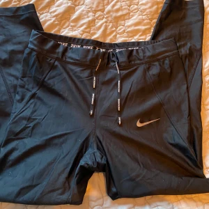 Träningstights nike - Nike träningstights- lite glansiga i materialet  Dras ihop med snörning Storlek M Använda ca 5ggr Nypris 699kr Rök och djurfritt hem!