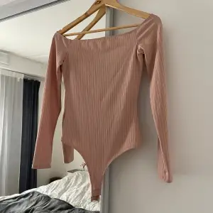 Body från Nelly.com. Färgen är beige och materialet är ribbat. 