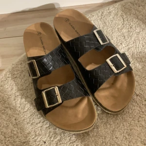 Svarta/bruna sandaler - Ett par svarta och bruna sandaler. Storlek 40 och går att ändra längden på banden. Köpta i somras på skopunkten för 300 kr. Använda bara några gånger då de hann bli försmå. Pris kan diskuteras!