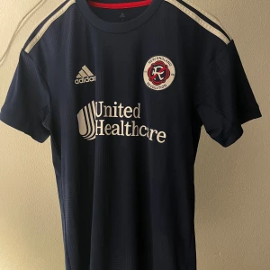 Fotbollströja MLS - Tjena! Här en en stilren och sällsynt tröja från New England Revolution lanserade 2022 ett specialtröja vid namn ”Liberty Kit" Använd ett fåtal gånger och har växt ut den.  Unik tröja köpt i deras officiella butik i USA! Vid frågor skriv!