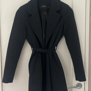 Svart kappa från Vero Moda  - Svart kappa i storlek xs från vero Moda. Säljer då jag ej använder den. Nyskick, använd ett par gånger.