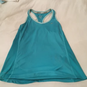 Tränings linne i märket Nike  - Turkost linne i Nike Storl S Katt finns i hemmet 