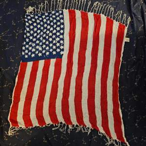 Sjal med tofsar från Kappahl som liknar amerikanska flaggan. 100% viskos.