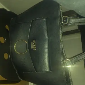 Säljer min unika Guess väska som inte finns längre, den har 5 fickor och är perfekt till skolan eller jobbet! Den har mycket utrymme och får plats med mycket😌