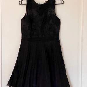 Svarta klänningen med flera lager av tjol som ger klänningen ”fluffig” effekt. Nät på klänningens topp ger elegant kännsla.  Bra skick (använd 1 gång). 