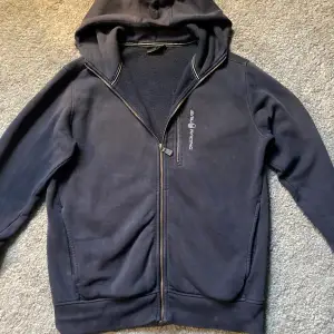 Säljer min sail racing zip hoodie då den inte andvänds. Den är i storlek M och är i bra skick. Kan vara små fläckar men inga synliga när man har på sig den. 