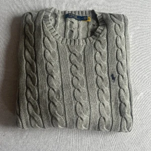 Ralph Lauren kabelstickad  - Grå kabelstickad Ralph lauren i mycket bra skick. Nypris ligger på 2200. Bara att skriva för fler bilder eller frågor! 