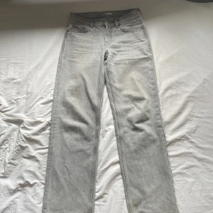 Straight jeans från Gina Tricot  - Ett par ljusgrå jeans i modellen straight. Köpta på Gina Tricot. De är i storlek 34, passar mig som är 166 cm. De är i fint skick utom små defekter längst ner på byxbenet och på fickorna, men det är ingenting som märks! Hör av dig vid frågor!🥰