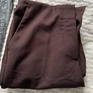 Bruna kostymbyxor  - Bruna kostymbyxor med lite bootcut från HM helt oanvänd i strl 36.