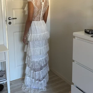 Vit sommar klänning - Vit flowy sommar klänning med spets detaljer som jag använt ett par gånger på fester. Väldigt skön och har lite stretch. Har underkjol så den är bara see-through på ryggen och magen. Jag är 170. Skriv gärna till mig på insta ifall jag inte svarar här