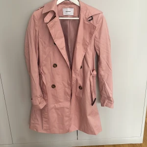 Rosa kappa  - Snygg rosa kappa som aldrig kommer till användning! otroligt fin färg, kappan är tun och perfekt att använda på våren! Köparen står för frakten!