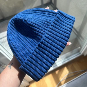 Blå Mössa från ARKET - Jättefin blå mössa som sitter ascoolt! En sån passform som sitter ”högt upp på huvudet” eller vad man säger 😅 Helt ny säljer pga för liten för mig.