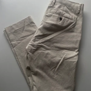Beige Riley herrchinos 48(M) slim fit - Beige herrchinos / linnebyxor. Från Riley / Brothers storlek 48 slim fit (motsvarar M)
