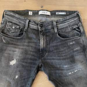 Säljer nu dessa feta replay jeans med slitningar, skicket är perfekt inga defekter alls, jeansen är i storlek 31/32 och är i modellen anbass slimfit i färgen mörkgrå. Jeansen är slutsålda i just denna färgen eftersom den är väldigt eftertraktat.