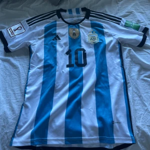 WORLD CUP 2022 Argetina tröja- Messi - Mycket fin tröja som aldrig är använd med Messi på ryggen. Tröjan när Messi och Argetina tog hem sitt VM guld 2022 