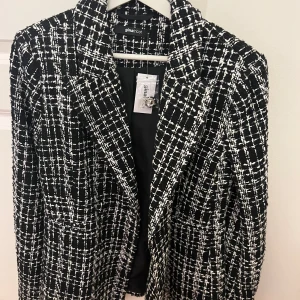 Kavaj - Super snygg kavaj med svart vitt mönster. Har litet puff vid axlarna som gör den till extra lyxig. Köpt från Gina men kommer inte till användning. Helt ny!! Aldrig använd. 