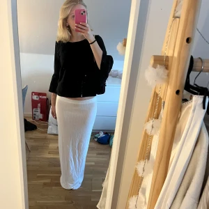 Långkjol - Säljer denna superfina vita stickade lowwaist långkjolen från Nelly i storlek s. Är 169 lång och den sitter perfekt. Endast använd en gång så den är som ny💕