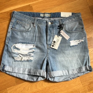 Jeans shorts  - Jeans shorts splitterny med prislappen på, storlek 40 vintage look m d slitningar på framsidan . Mjuka och generös i strl 