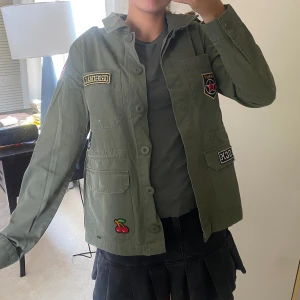 Najs jeansjacka - Jättenice jeans-militärjacka. Köpt förra året men knappt använd, patcheserna går att ta bort. Nyskick 