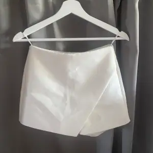 Jättesnygg vit kjol med shorts, finns en liten fläck på baksidan 