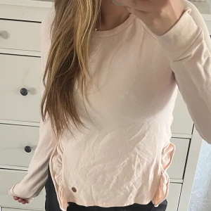 Rosa tjocktröja med volang   - Jag säljer en fin rosa tjocktröja med volang och en slit vid sidan. Den är slutsåld från kappahls barnavdelning. Tjocktröjan är från Kappahl och har ett mjukt material med fina detaljer. Tröjan är i fint skick dock tyvärr lite skrynklig på bilderna💕