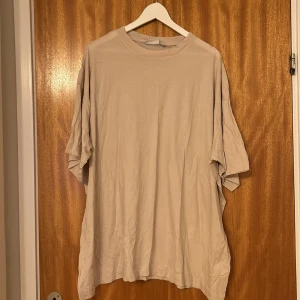Lång t-shirt  - Lång beige t-shirt, använd 1 gång 