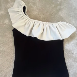 One shoulder topp - Jätte fin svart vit one shoulder topp från HM.  Storlek Xs och i bra skick!!