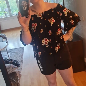 Topp  - En blommig topp, går till naveln ungefär. Använd ett fåtal gånger. Passar perfelt till en tajt kjol. Luftigt material. Köpt från affären new yourker   Köparen står för frakten 